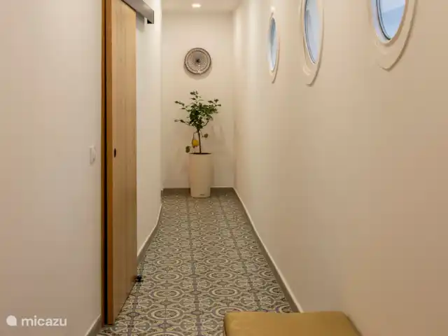 Hal vanaf entree tot de keuken met aan weerszijde de woonkamer, badkamer en 2 slaapkamers.